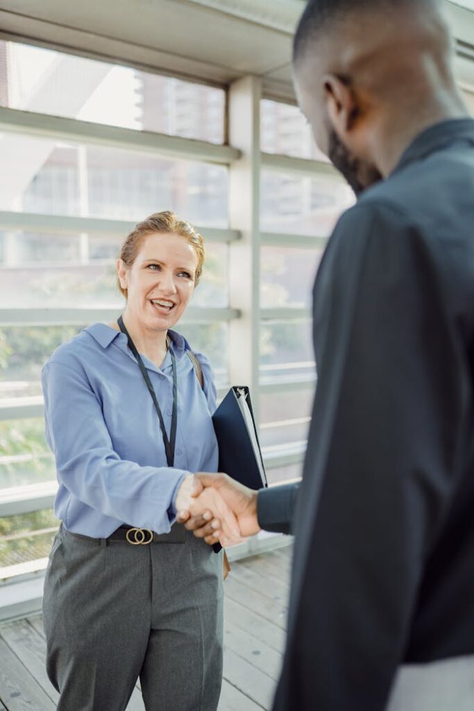 Woman and Man Shaking Hands in a Hallway